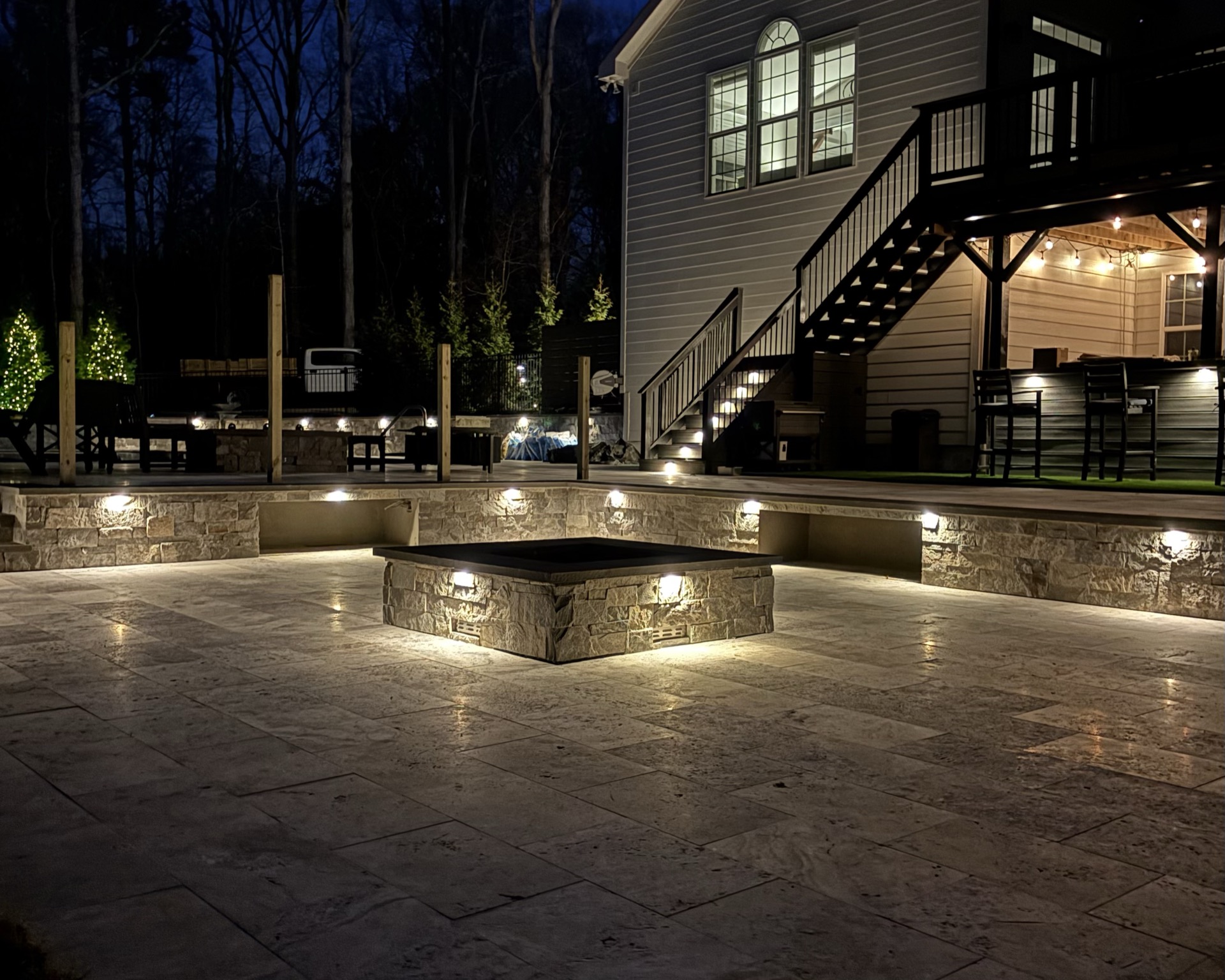 Outdoor lighting & stone firepit at night