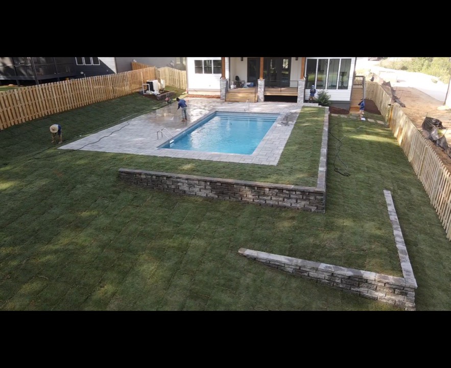 Aerial drone shot of rectangle pool with retaining wall