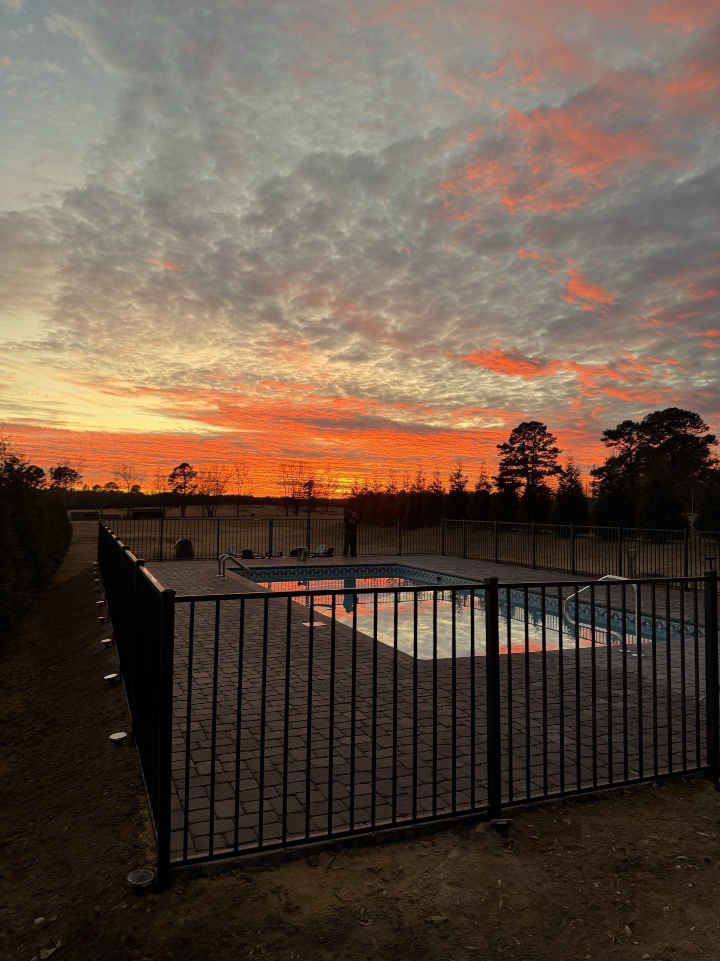 Sunset over pool with iron fence